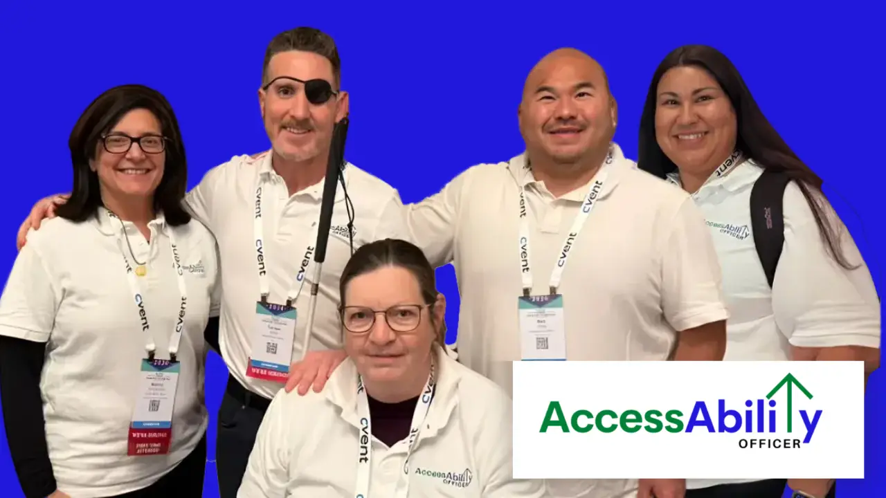 AccessAbility Officer team members wearing white polo shirts and conference badges pose together against a blue background. Tanner Gers wears an eyepatch and holds a white cane. The AccessAbility Officer logo appears in the lower right corner.