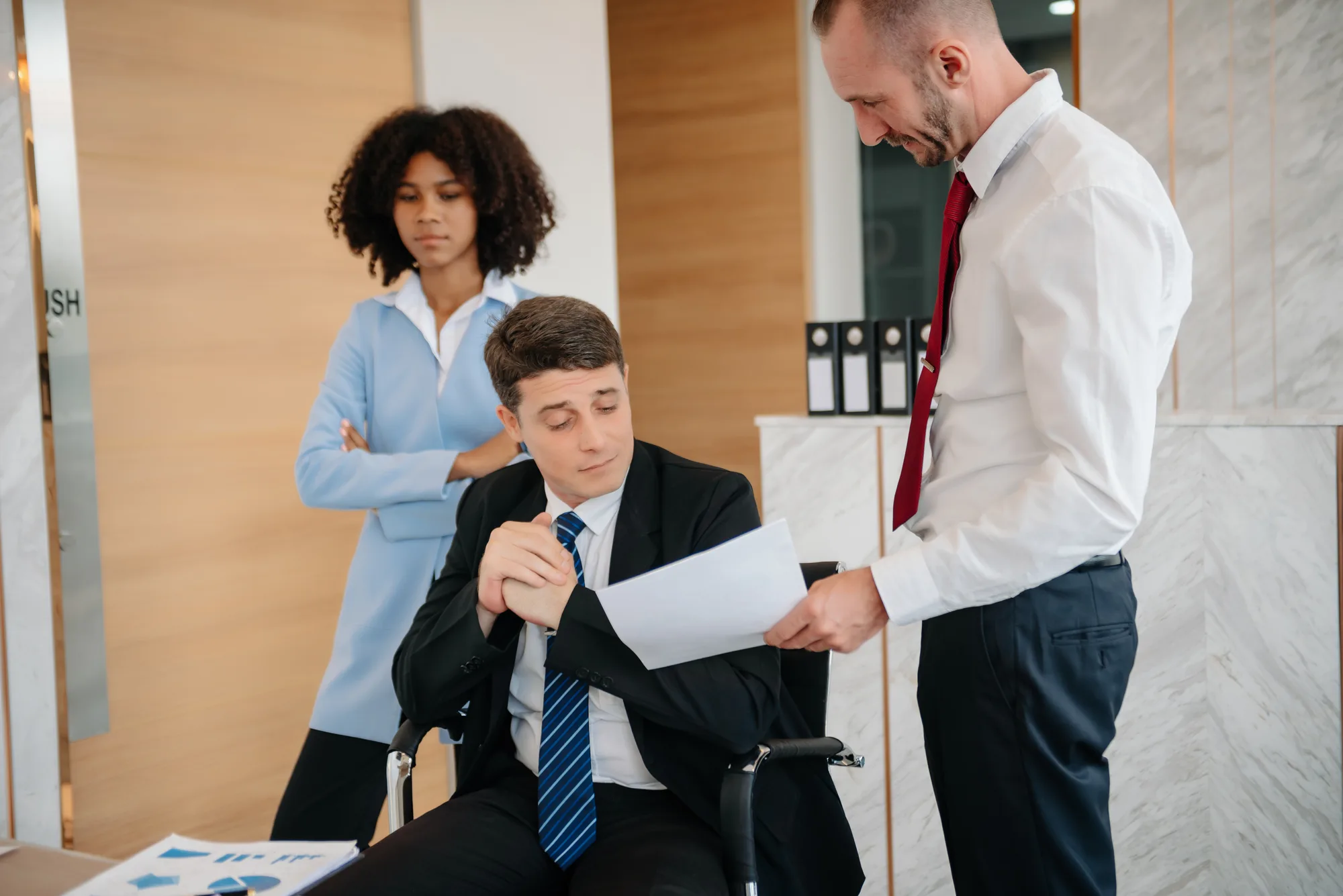 Finance team reviewing a risk report, with one team member using a wheelchair