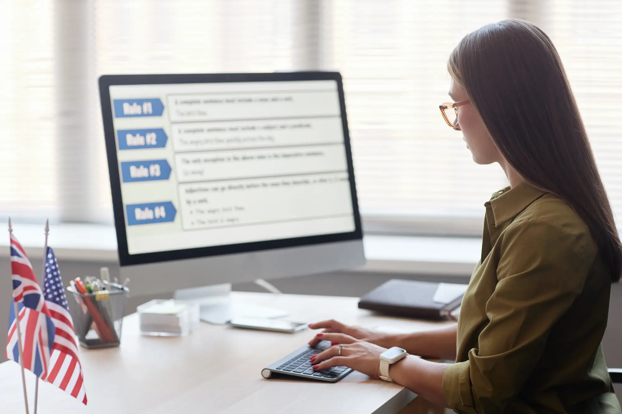 Woman reviewing accessibility requirements displayed on a computer monitor while working at a desk.