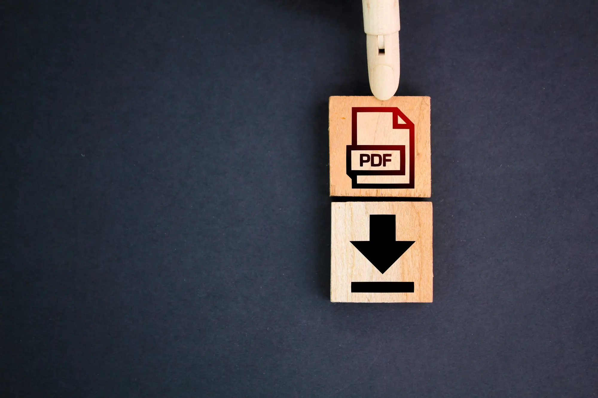Wooden blocks with PDF icon and arrow on dark background, minimal and focused layout