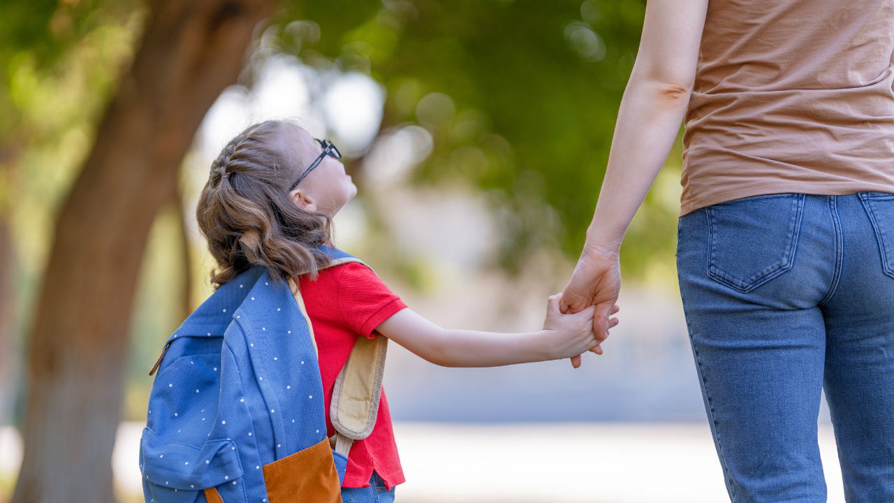 Child with glasses holding a caregiver’s hand on the way to school, representing parental advocacy in disability rights education after the A.J.T. v. Osseo ruling.