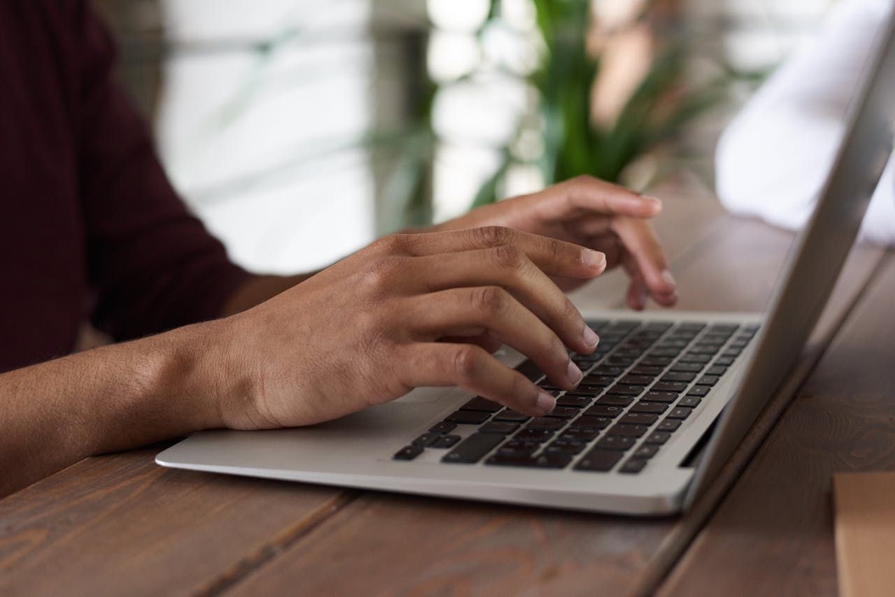Hands typing on a laptop.