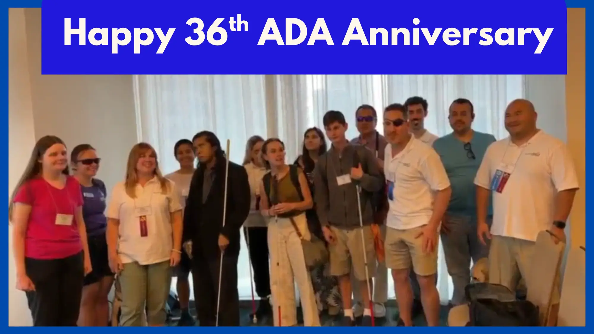 AO team members and Testathon participants stand together and smile for a group photo, several holding white canes. A banner across the top reads "Happy 36th ADA Anniversary."
