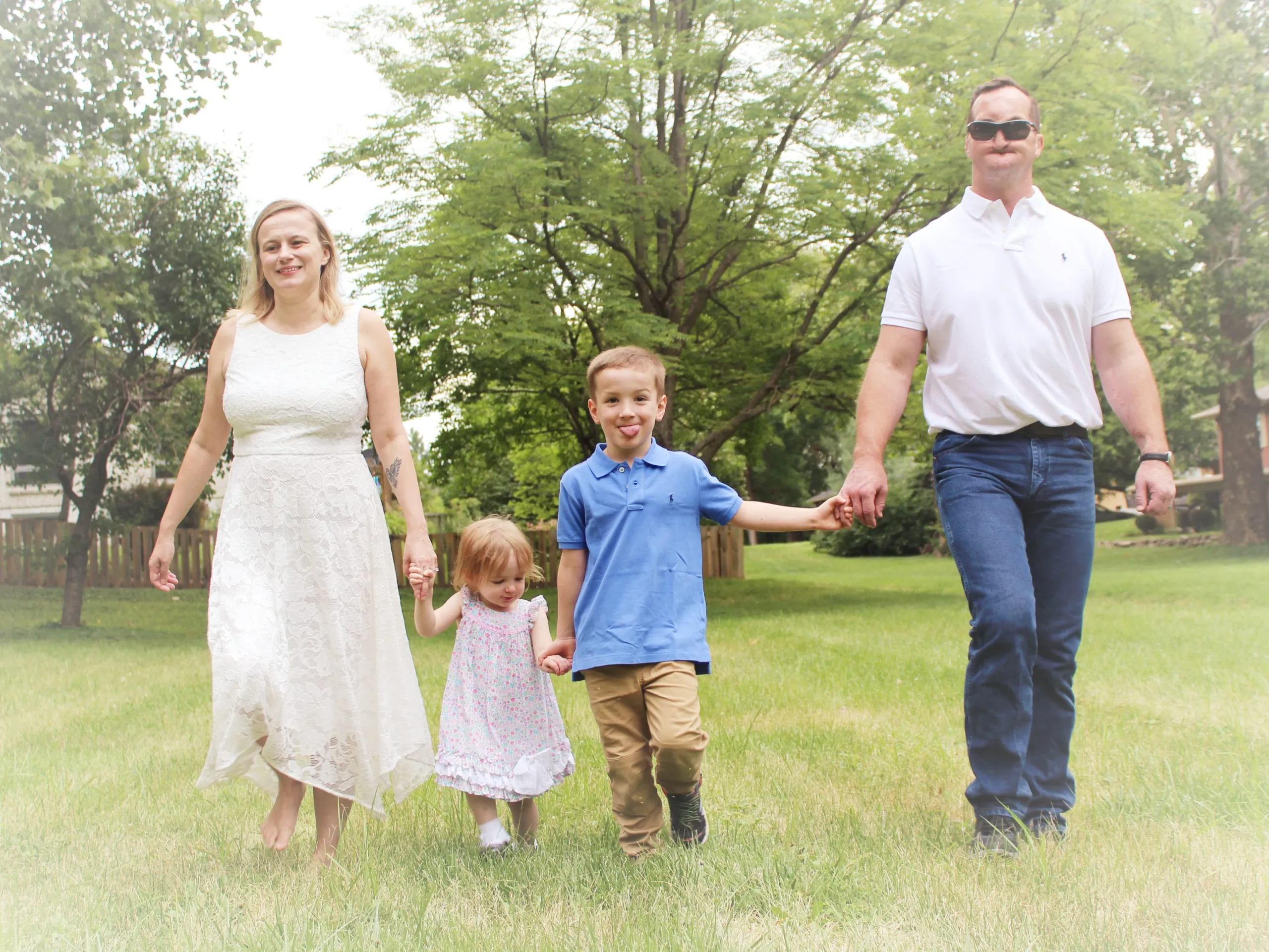 The Cervenka family, blind parents with their two young children, holding hands while walking in a park